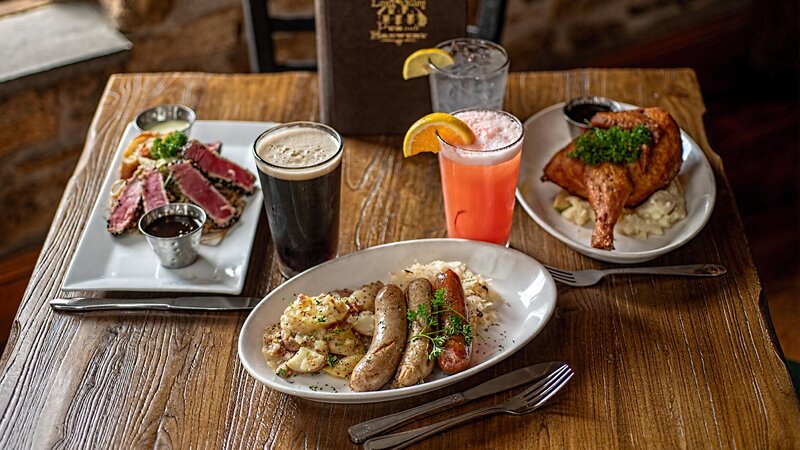 Multiple plated entrees and drinks on a table
